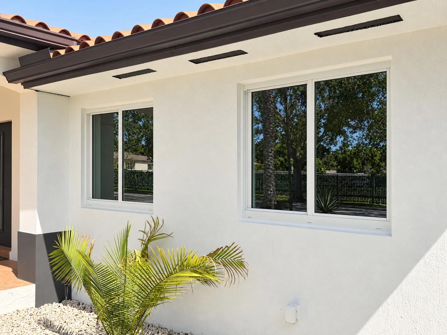 Dark-framed windows on a white South Florida residence